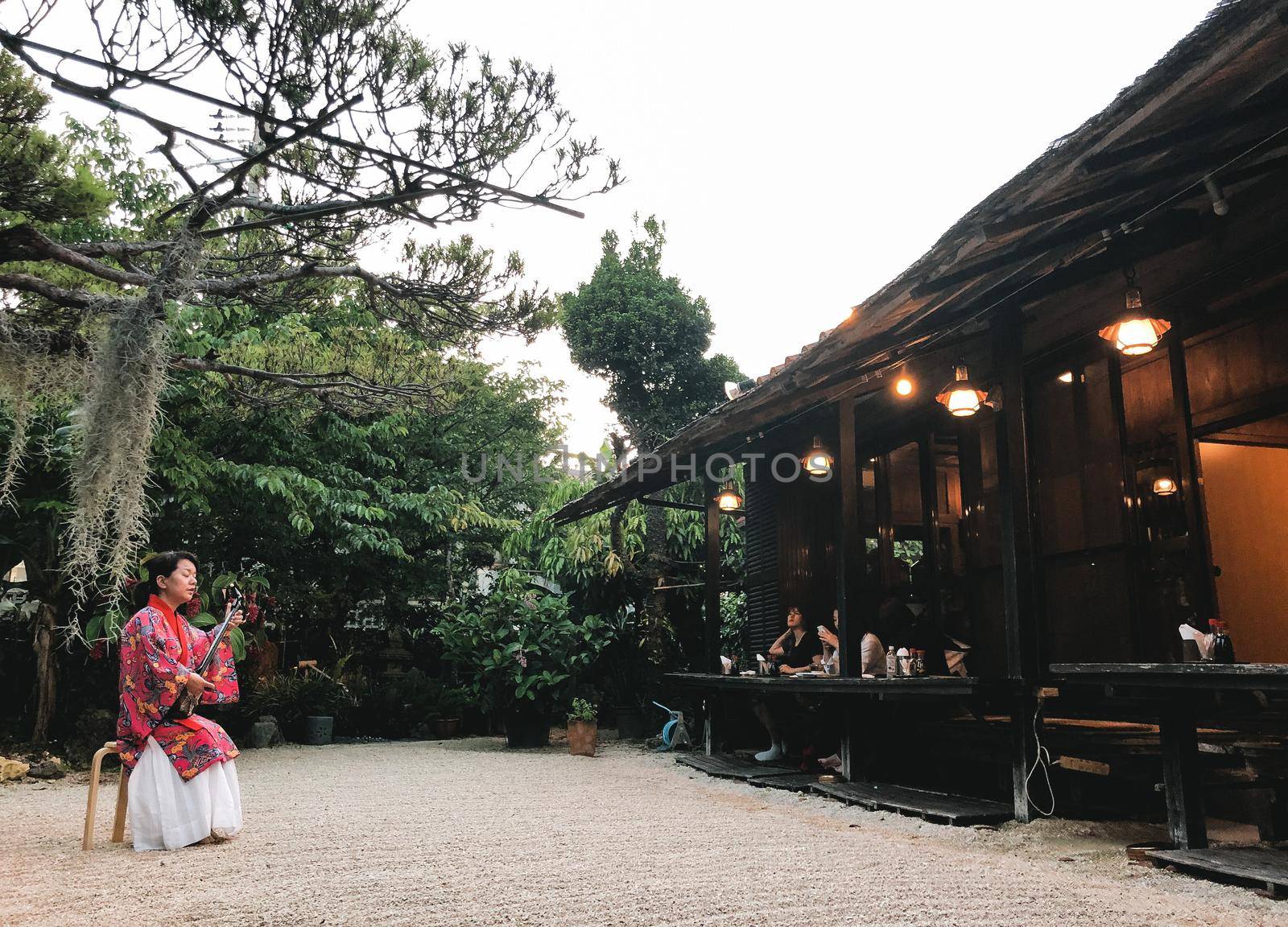 Naha Okinawa, May 21, 2019 - A woman playing a sanshin wearing a traditional Okinawan costume in the restaurant