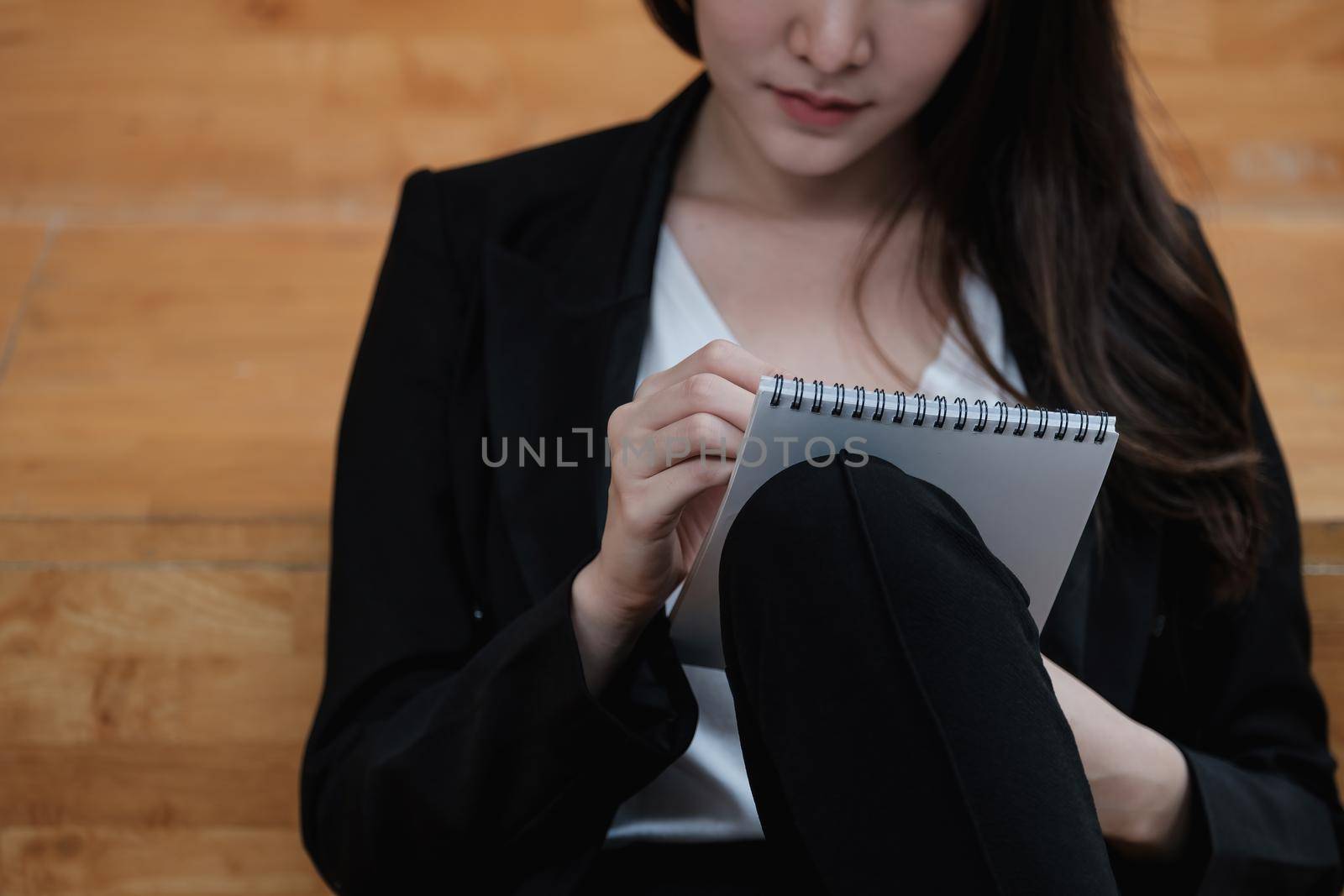 Cropped image of a businesswoman jotting down ideas on a notepad.