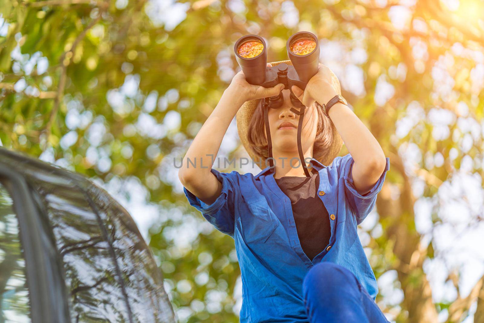 Close up Woman wear hat and hold binocular in grass field by stoonn