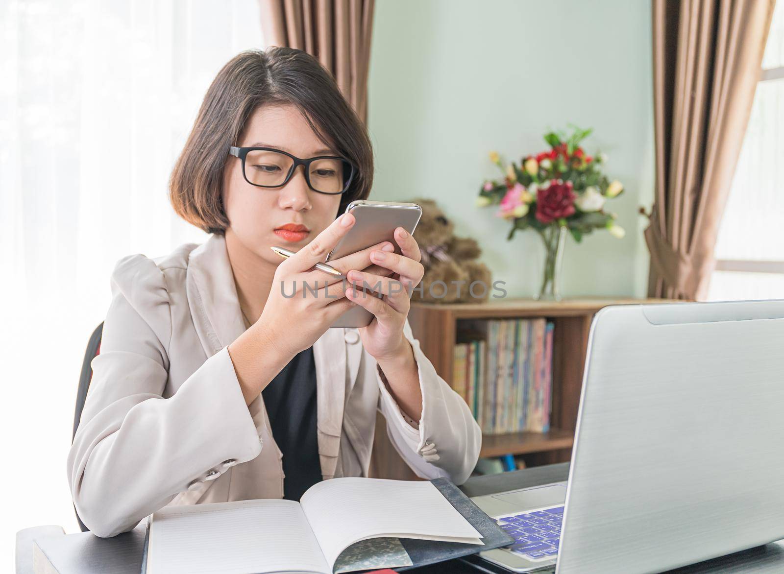 Teenage girl short hair in smart casual wear working on laptop while sit near window in home office