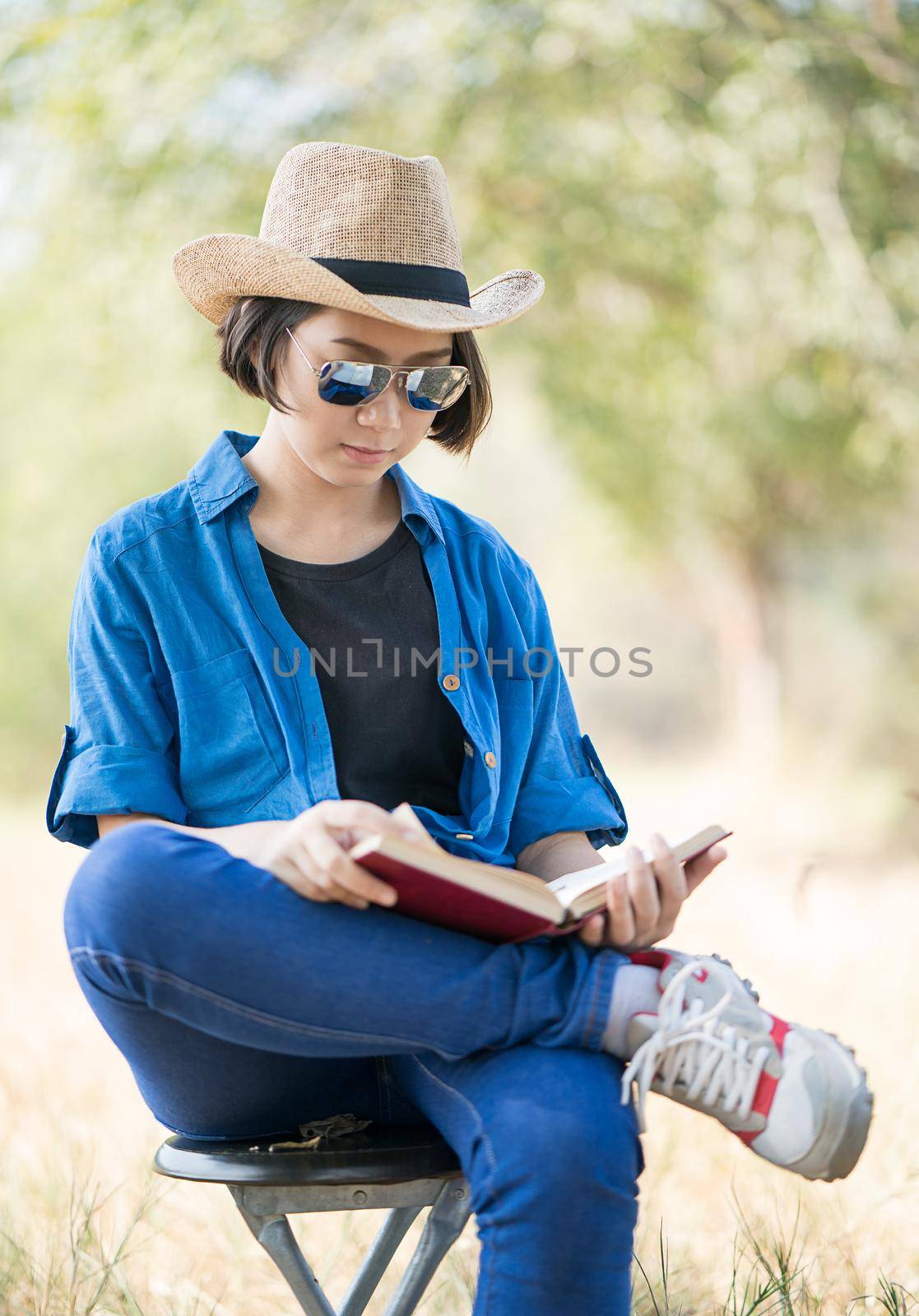 Woman wear hat and reading the book on chair by stoonn