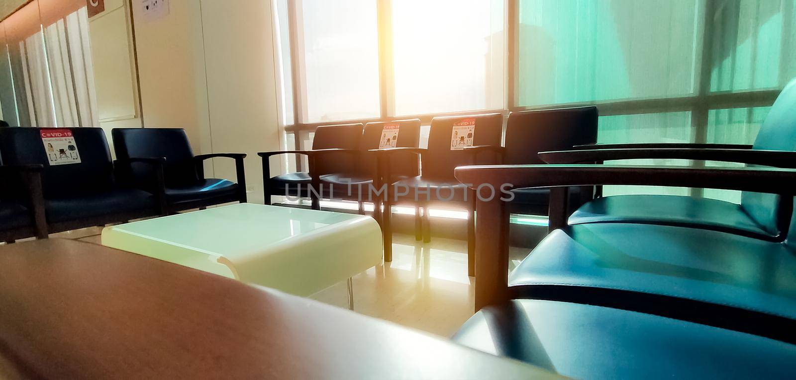 Social distancing. Empty dark blue chair with gap for social distance to prevent coronavirus (COVID-19) at waiting room in office for waiting queue. Public chair for social distancing in new normal. by Fahroni