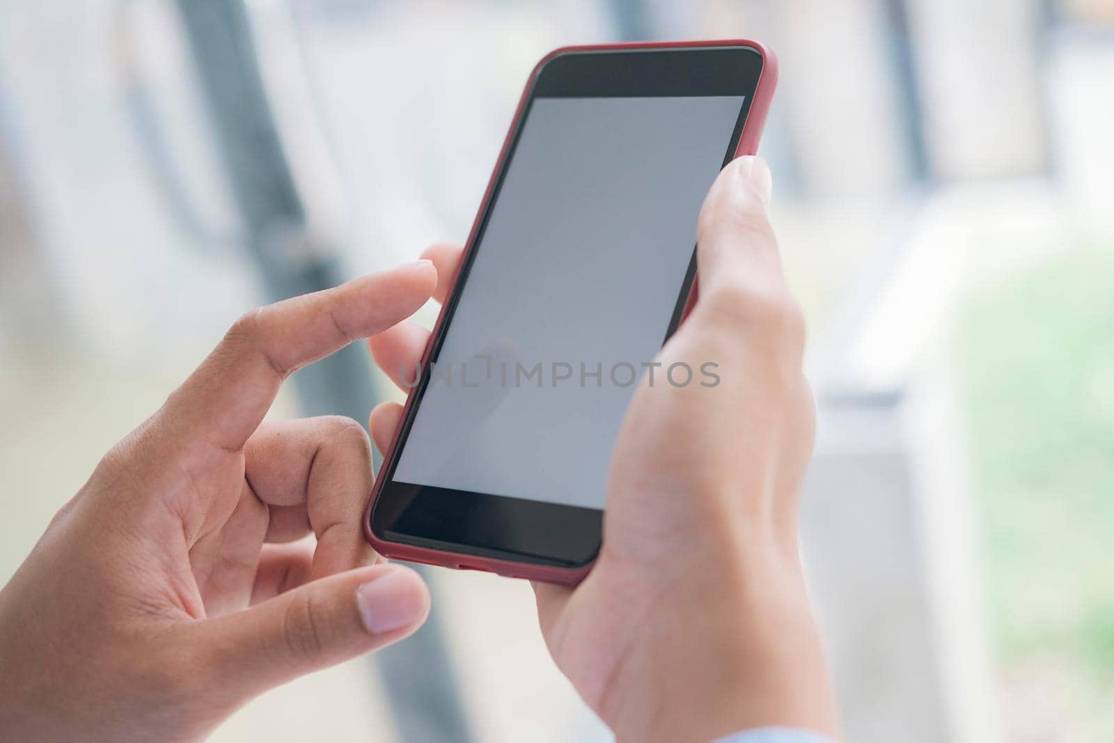 Close up of man hand holding smart phone. Blank screen mockup for graphics display montage.