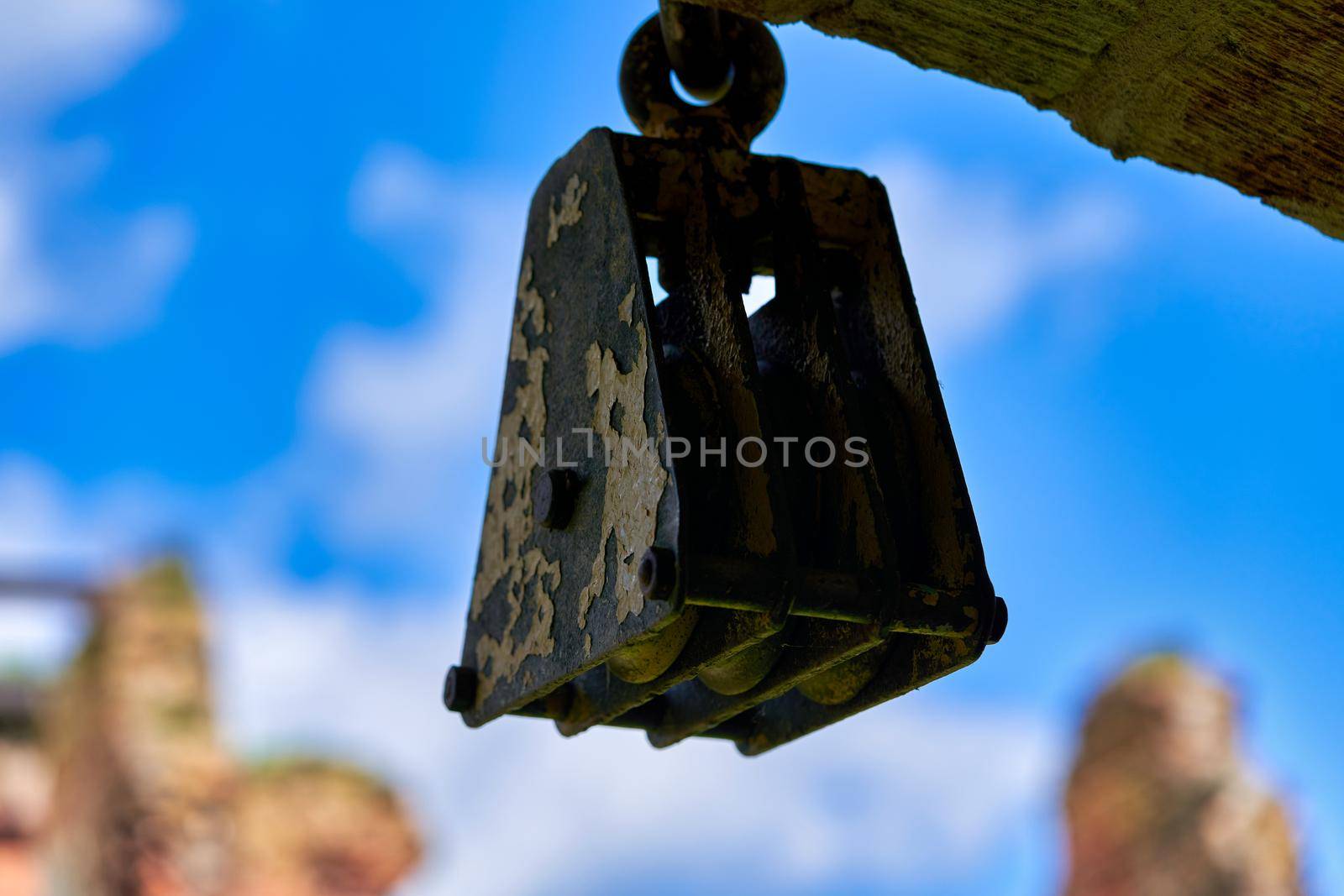 A fragment of an old lifting mechanism for using a rope in lifting loads. Elevator metal block