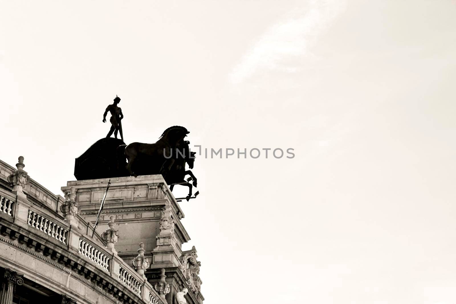 Beautiful quadriga statue on the roof of a building in Madrid