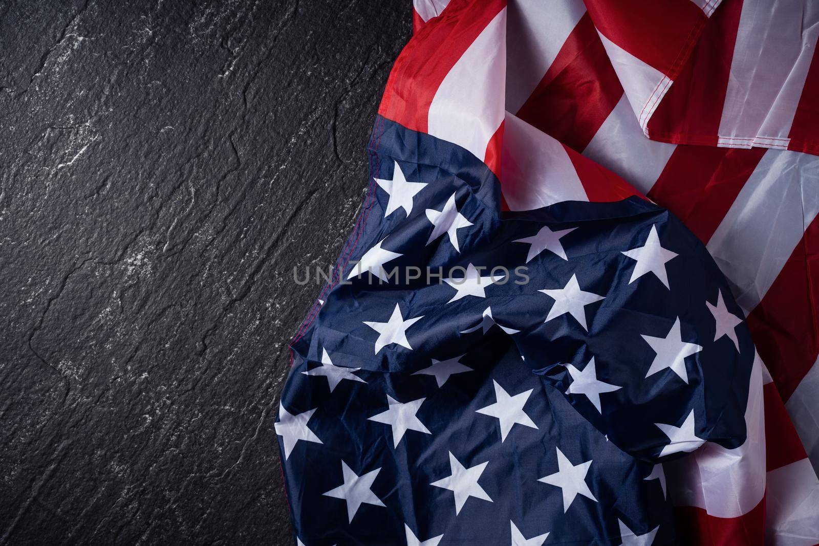 Concept of U.S Independence day or Memorial day. National flag over dark slate table background.