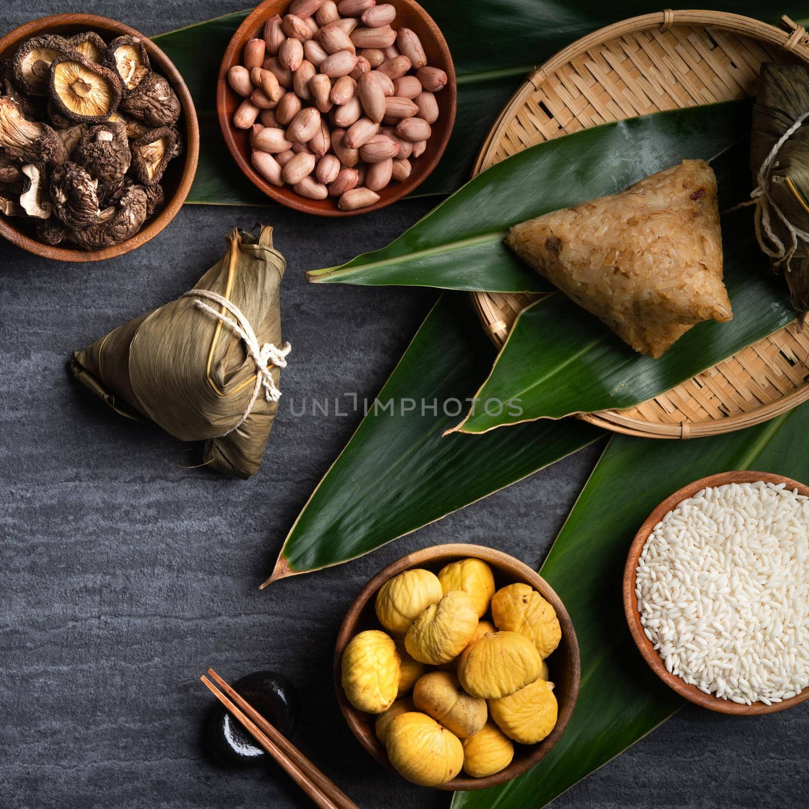 Zongzi. Rice dumpling top view design concept for Chinese traditional Dragon Boat Festival (Duanwu Festival) over dark black slate background.