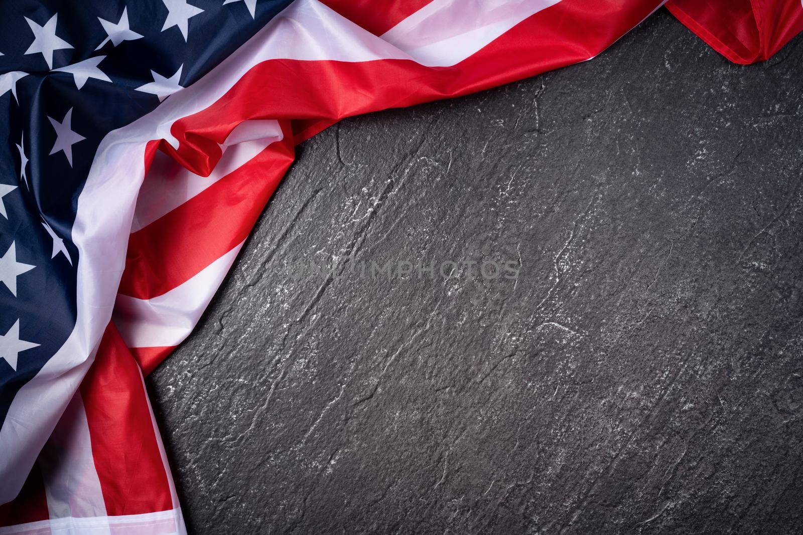 Concept of U.S Independence day or Memorial day. National flag over dark slate table background.