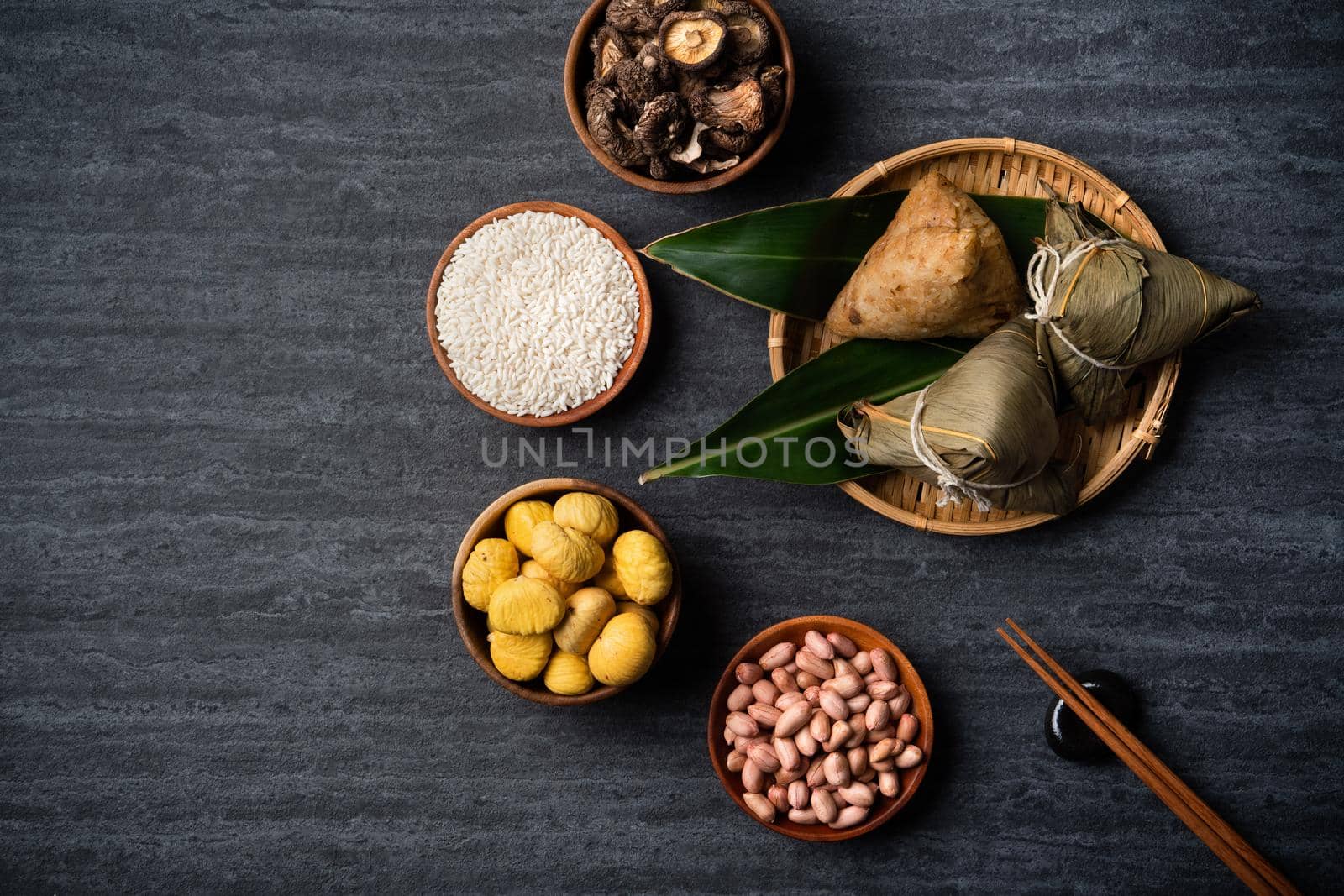 Zongzi. Rice dumpling top view design concept for Chinese traditional Dragon Boat Festival (Duanwu Festival) over dark black slate background.