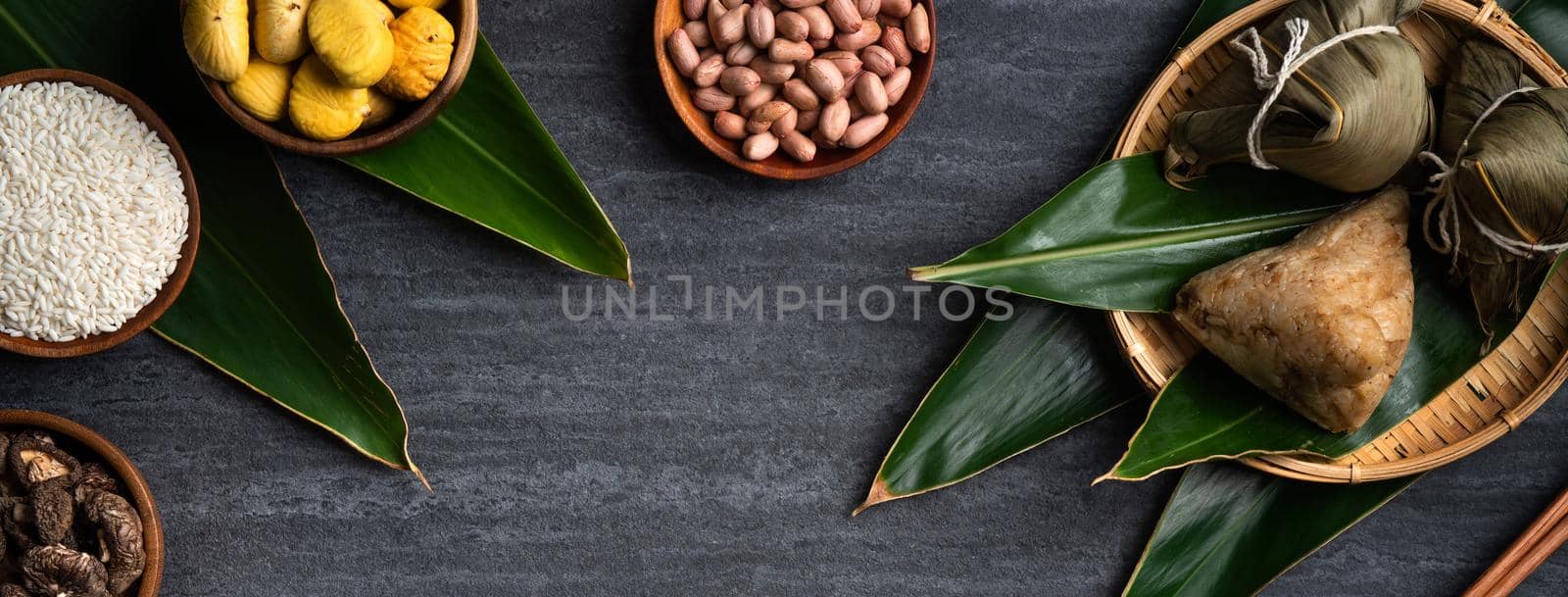 Zongzi. Rice dumpling top view design concept for Chinese traditional Dragon Boat Festival (Duanwu Festival) over dark black slate background.