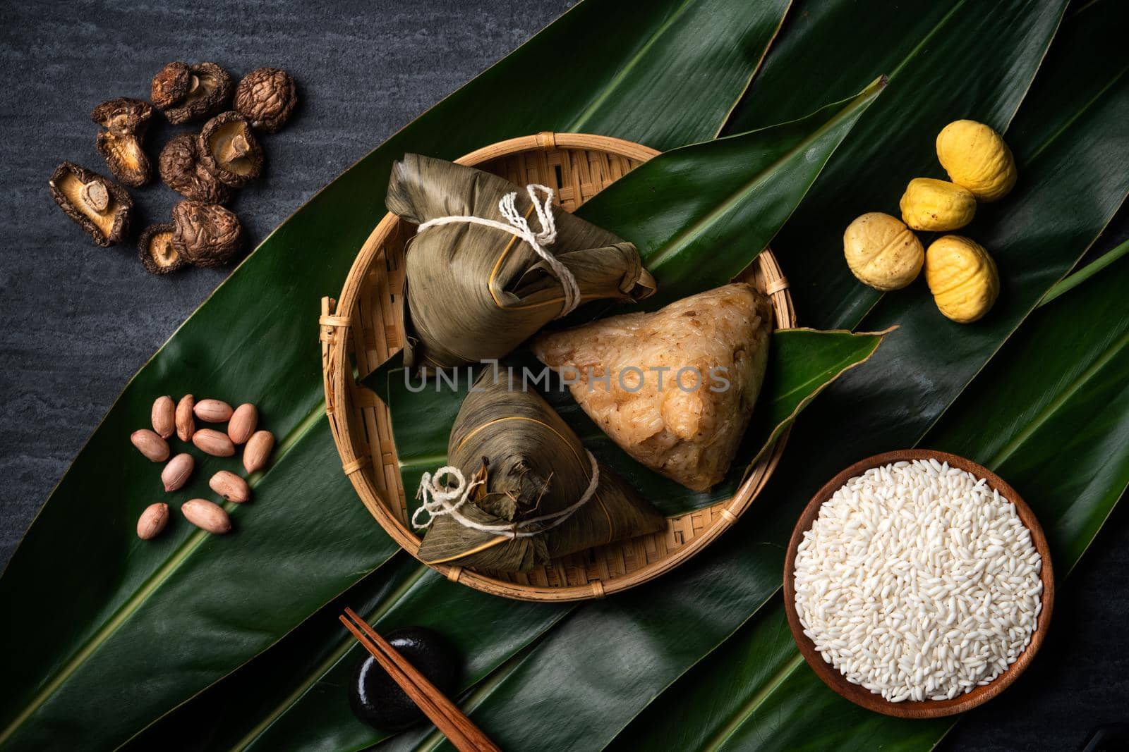 Zongzi. Rice dumpling top view design concept for Chinese traditional Dragon Boat Festival (Duanwu Festival) over dark black slate background.