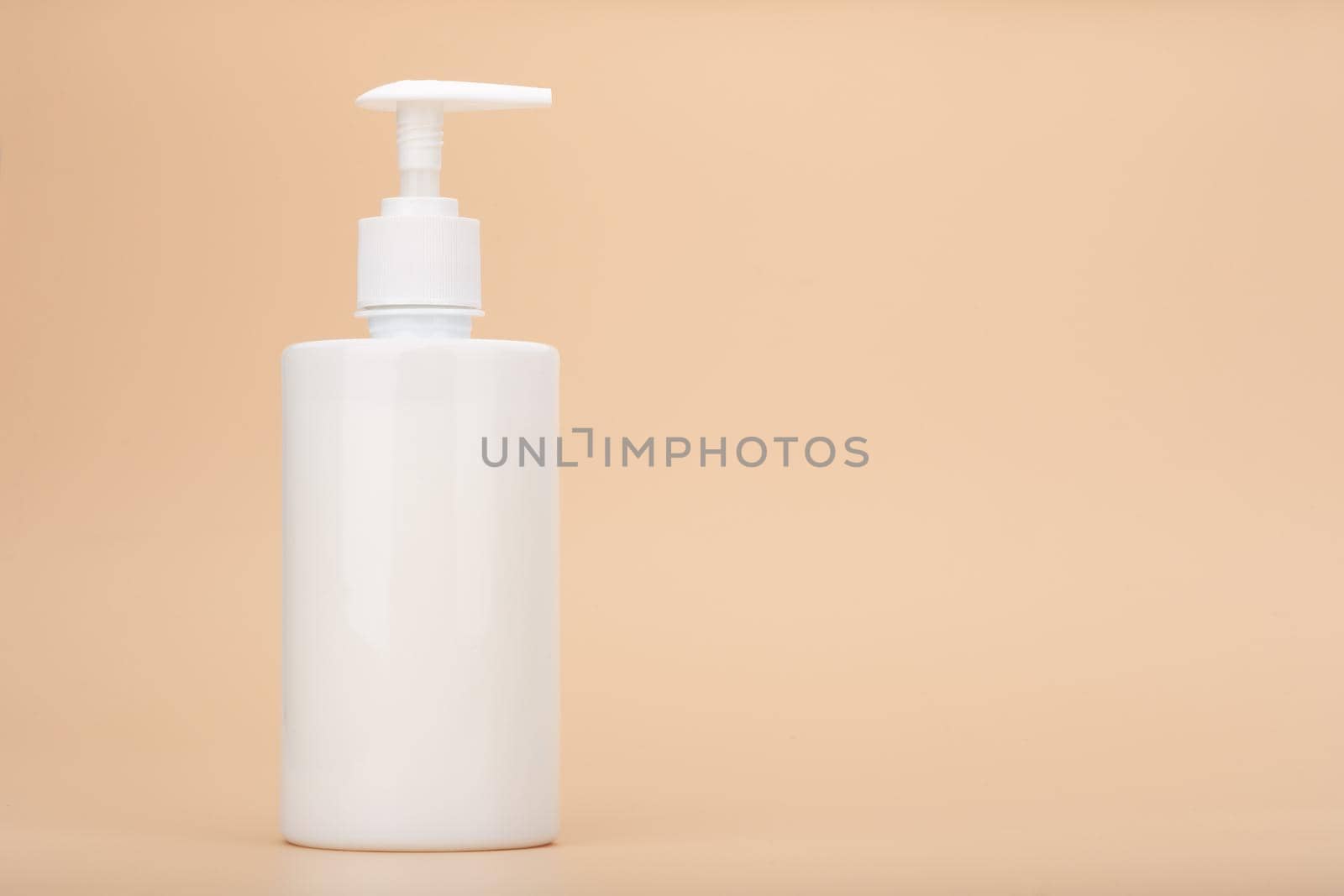 Shower gel, liquid soap or intimate gel in white unbranded tube against light beige background with copy space. Concept of intimate hygiene or gel for sensitive skin