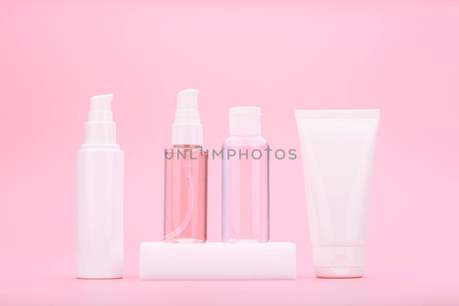 Set of beauty products for daily anti acne skin treatment against light pink background. Concept of regular skin treatment to cure acne