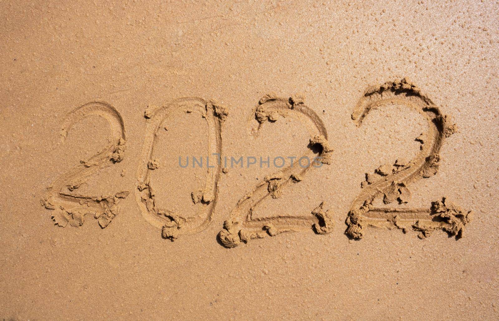 The numbers 2022 on the wet sand. The concept of the New Year 2022. Summer holidays and sea trips by lapushka62
