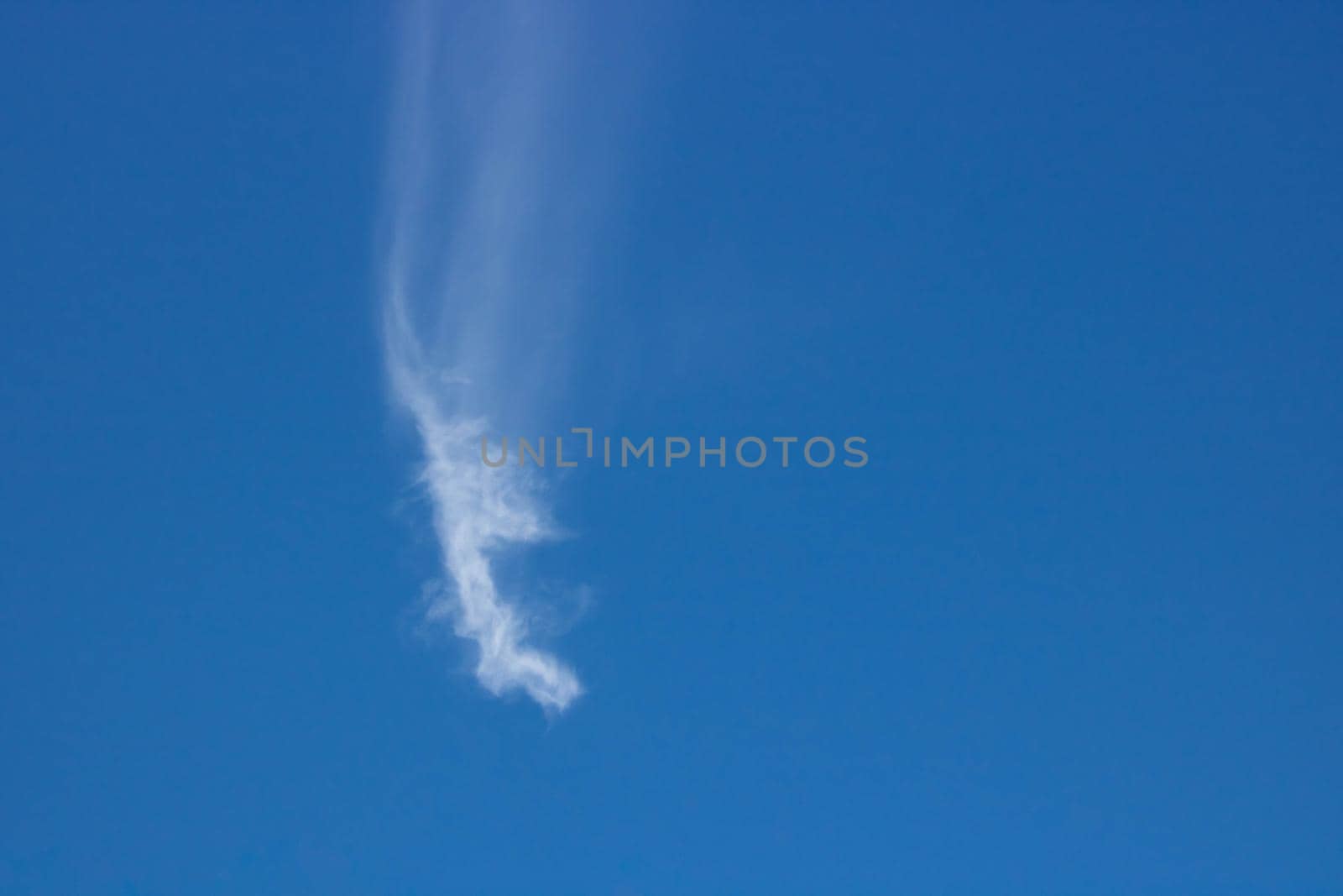 Blue, beautiful sky background. Oddly shaped clouds in a blue sky.