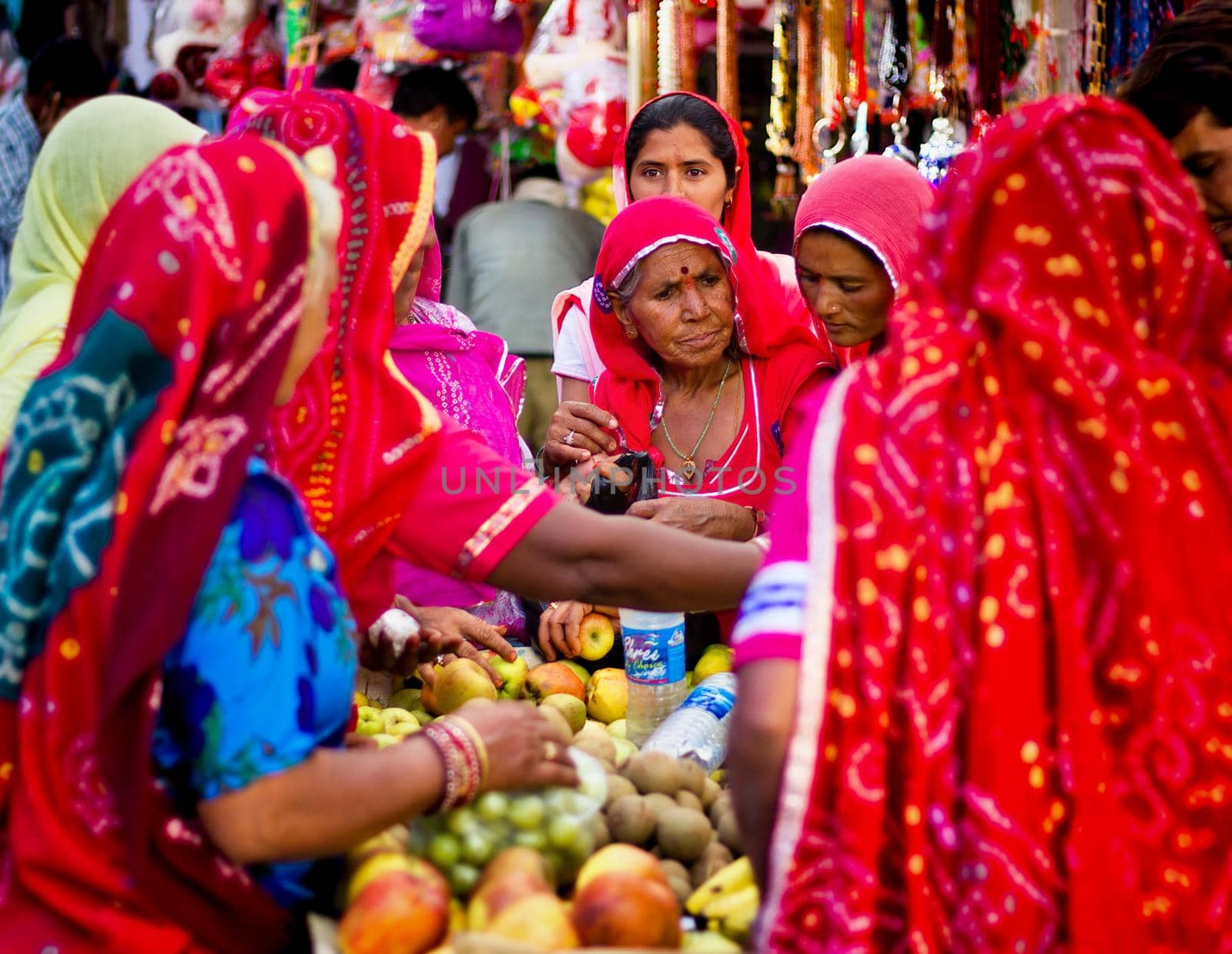 Pushkar, India - November 10, 2016: Few Indian women in colorful saree while covering their head buying fruits in group in the state of Rajasthan