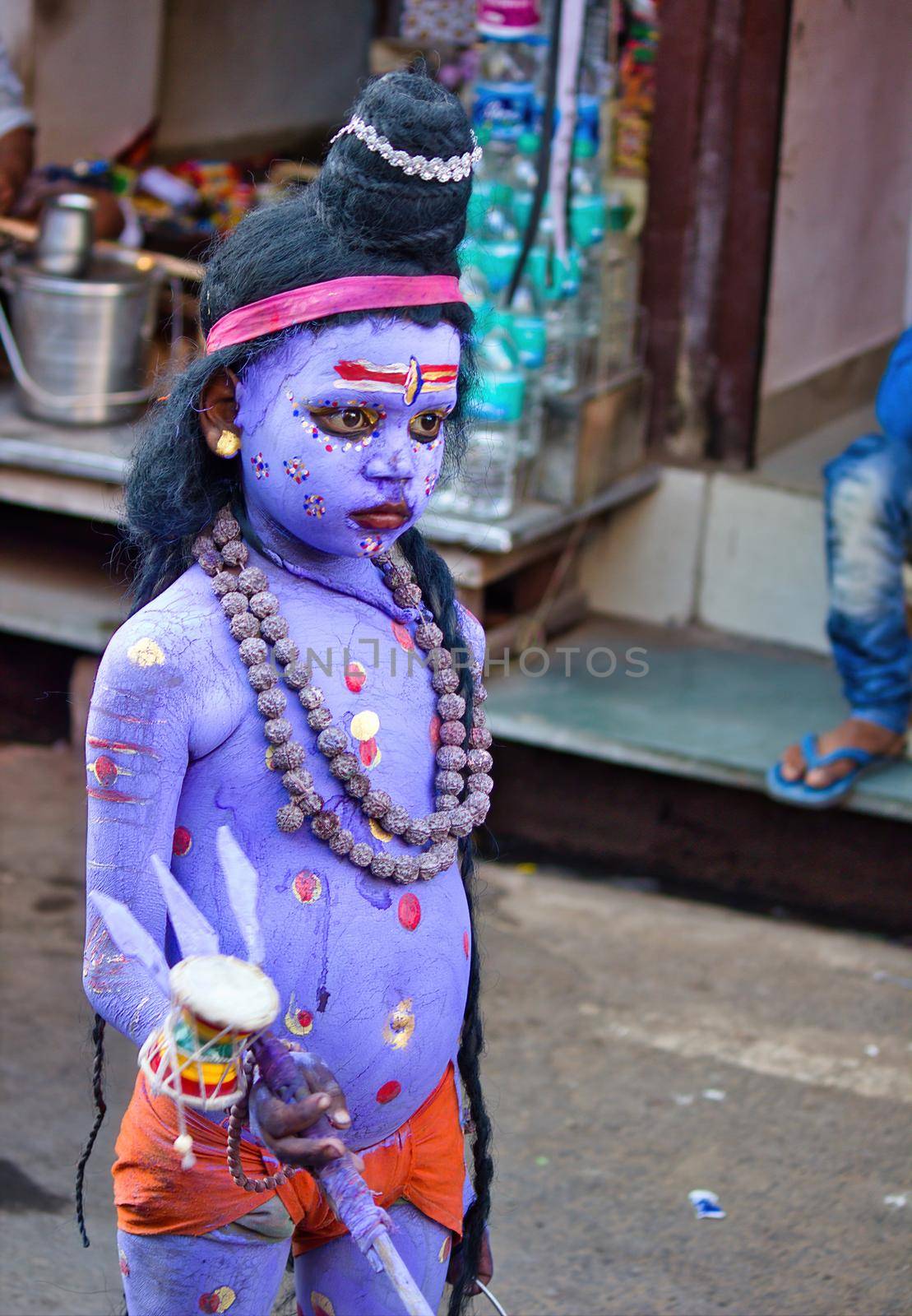 Pushkar, India - NOVEMBER 10, 2016: An unidentified boy dressed and disguised as hindu Lord Shiva with blue paint attends the Pushkar cattle fair in the state of Rajasthan by arpanbhatia