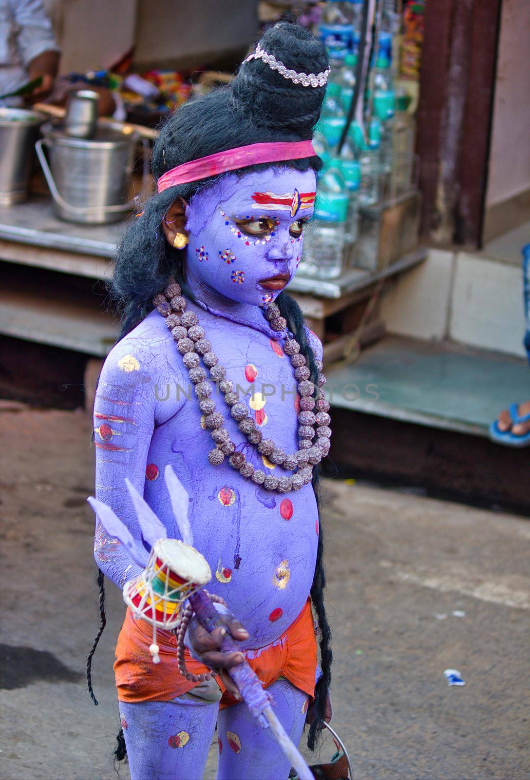 Pushkar, India - NOVEMBER 10, 2016: An unidentified boy dressed and disguised as hindu Lord Shiva with blue paint attends the Pushkar cattle fair in the state of Rajasthan by arpanbhatia