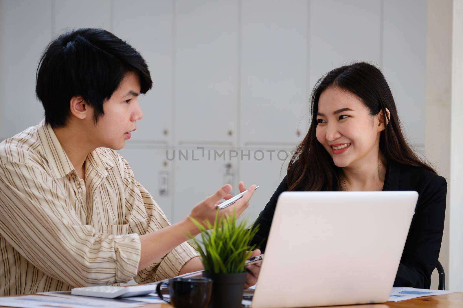 At the corporate headquarters, a business team works and discusses in a private meeting room. by itchaznong