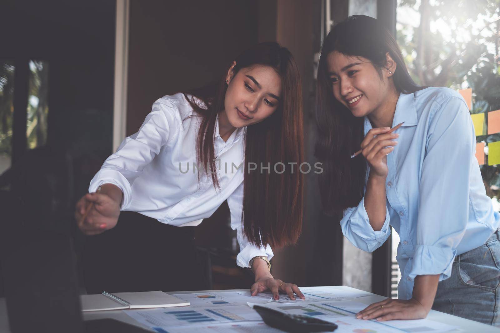 Diverse team of young business people dressed in formal wear cooperating on developing common design project and video call by laptop computer. by itchaznong