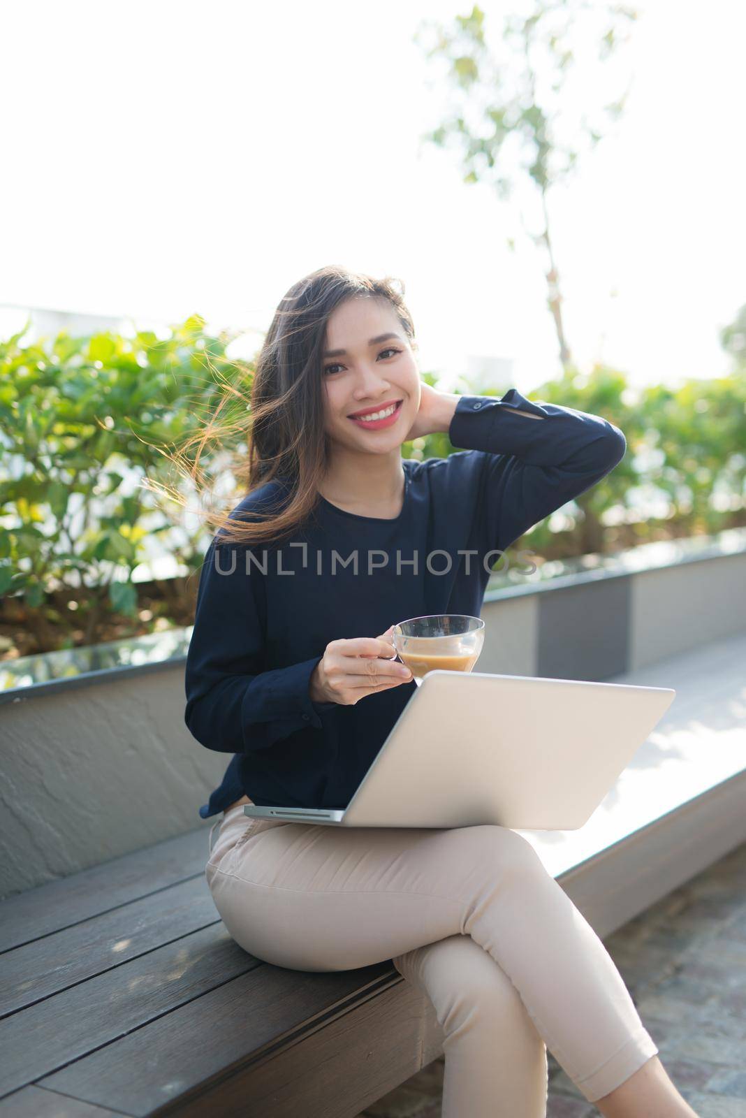 Young woman using laptop computer. Beautiful girl working on laptop outdoor