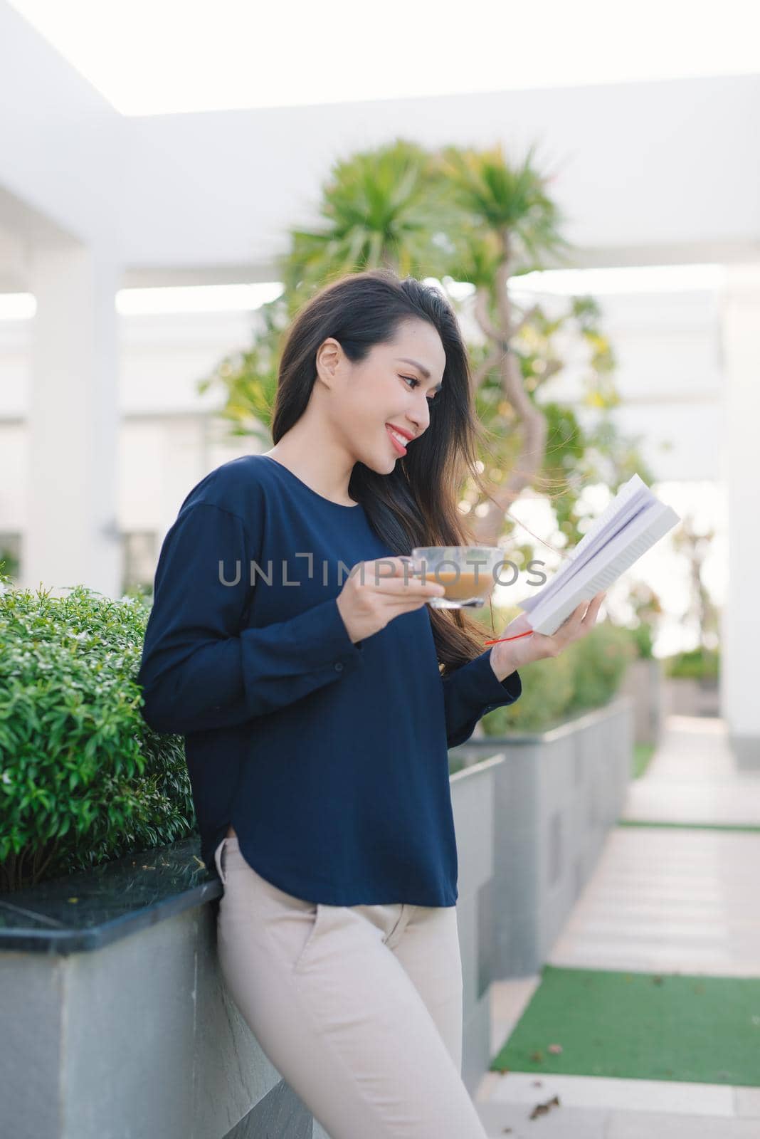 Young and pretty girl reading book on park in sunny day.