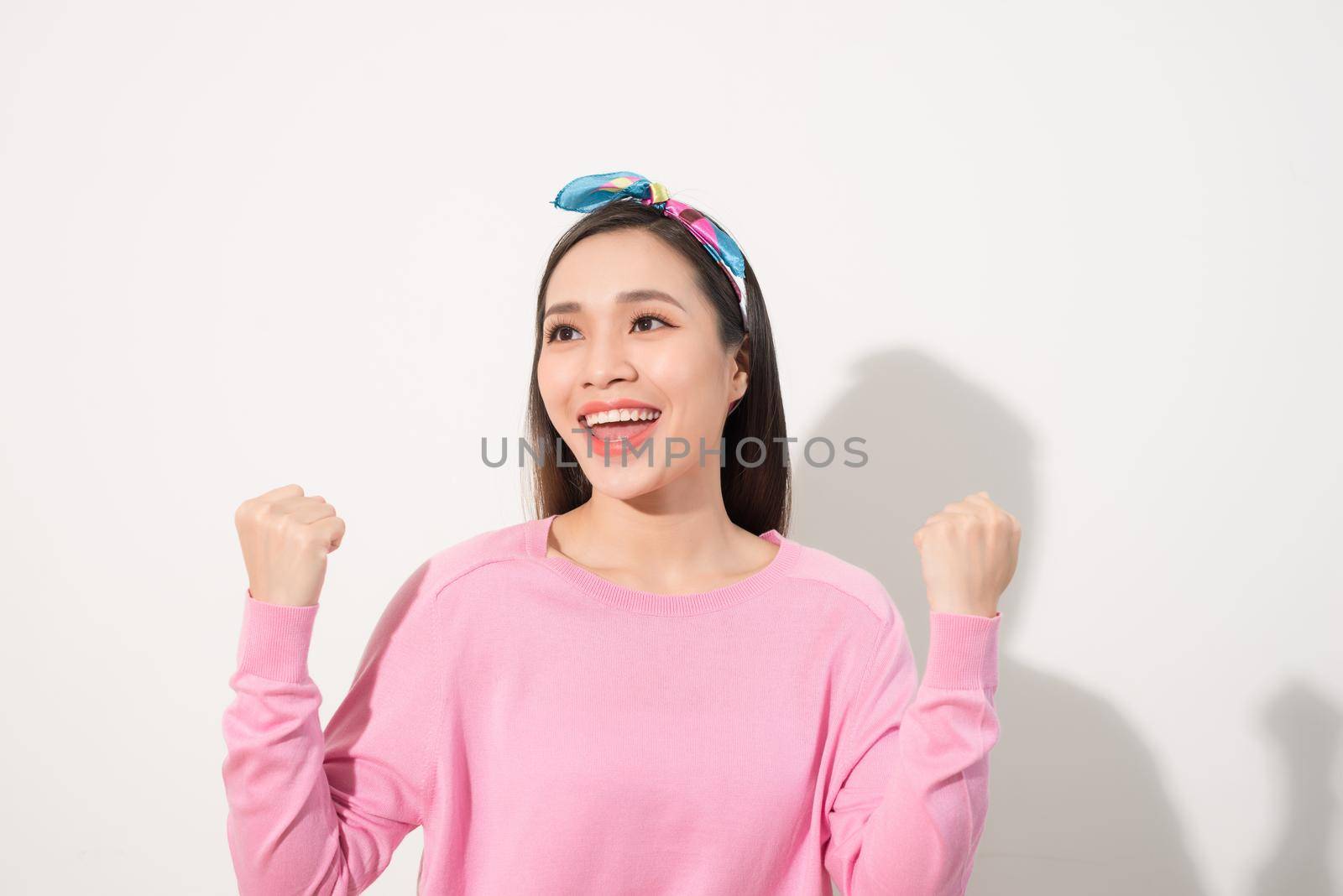 Surprised woman with hands up amazed or shocked by unexpected news holding close palms up and showing happy expression. Young adult woman on white background by makidotvn