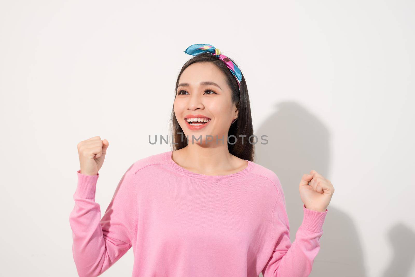 Attractive young woman relax and dance on copy space. Portrait of happy girl dancing your hands up on white background by makidotvn