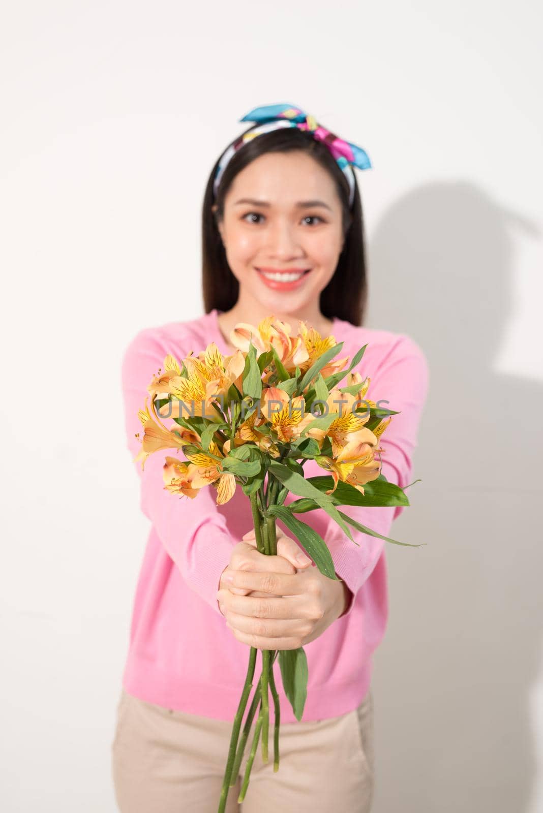 Toothy smiling happy woman holding flower . White background isolated portrait - image