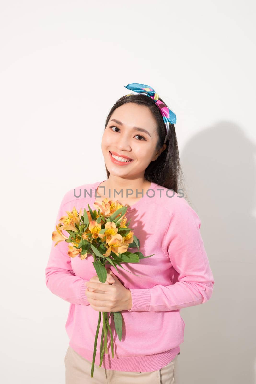 Toothy smiling happy woman holding flower . White background isolated portrait. by makidotvn