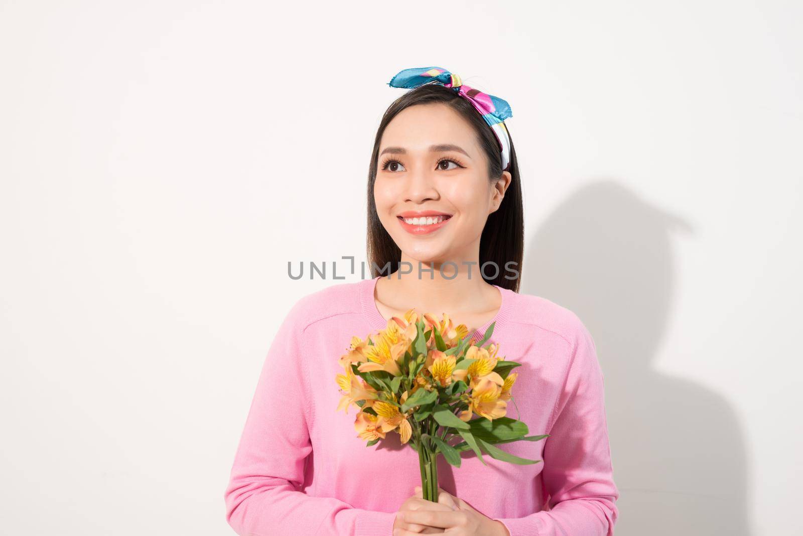Toothy smiling happy woman holding flower . White background isolated portrait.