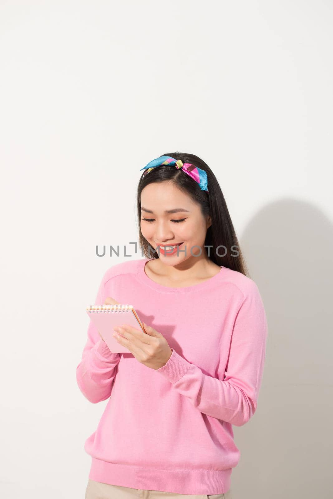 Portrait with copy space empty place of pretty, trendy, charming, nice, sexy, cute woman isolated on white background organizing her day, having notebook and pencil in hands by makidotvn