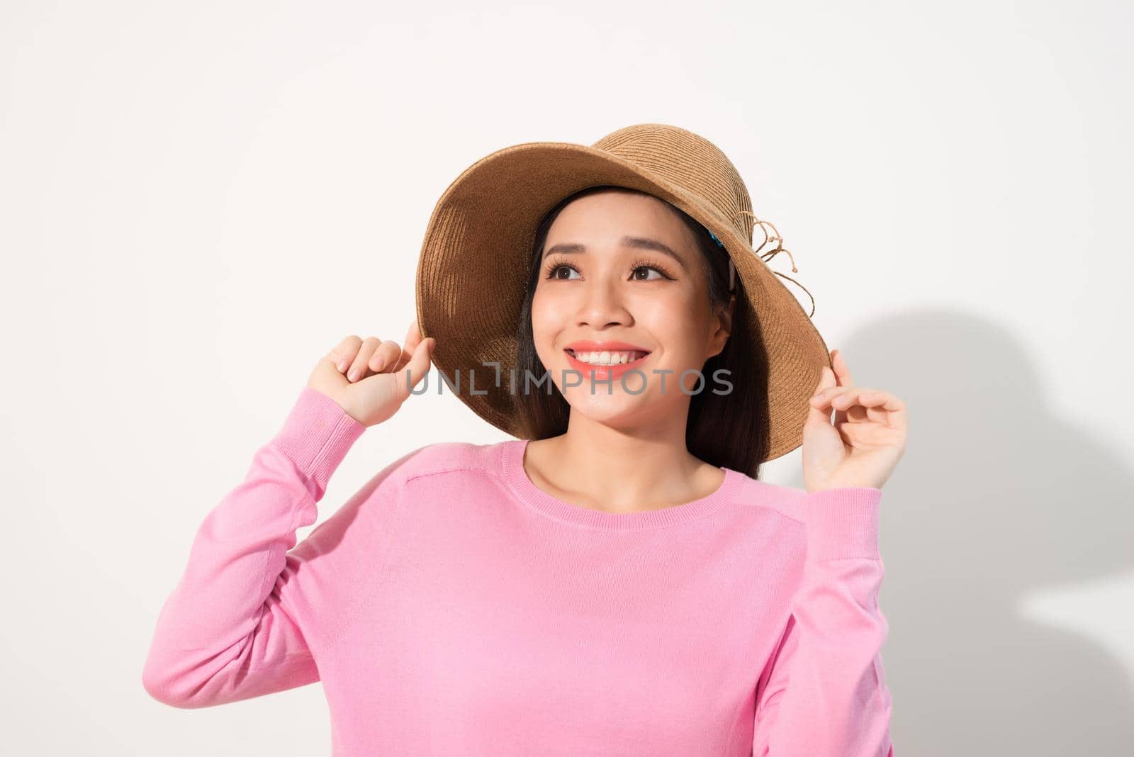 Portrait of a beautiful woman in a straw hat. Laughing girl. Summer time