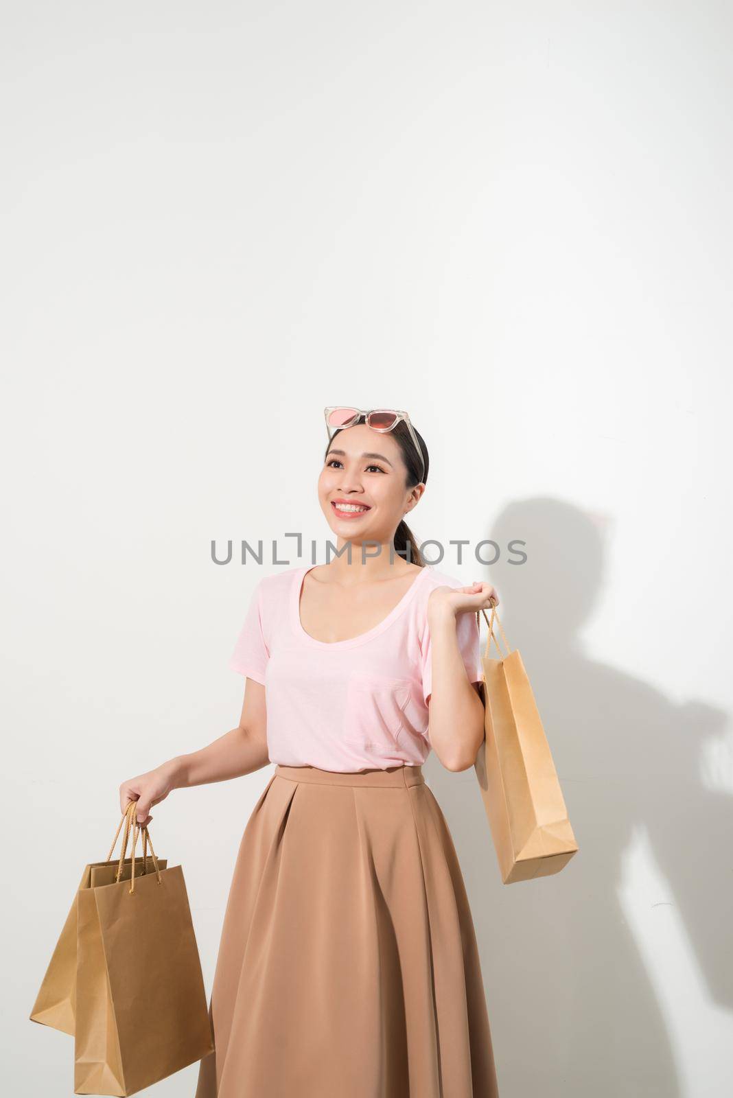 young woman with purchases on a white background, fashion, beauty by makidotvn