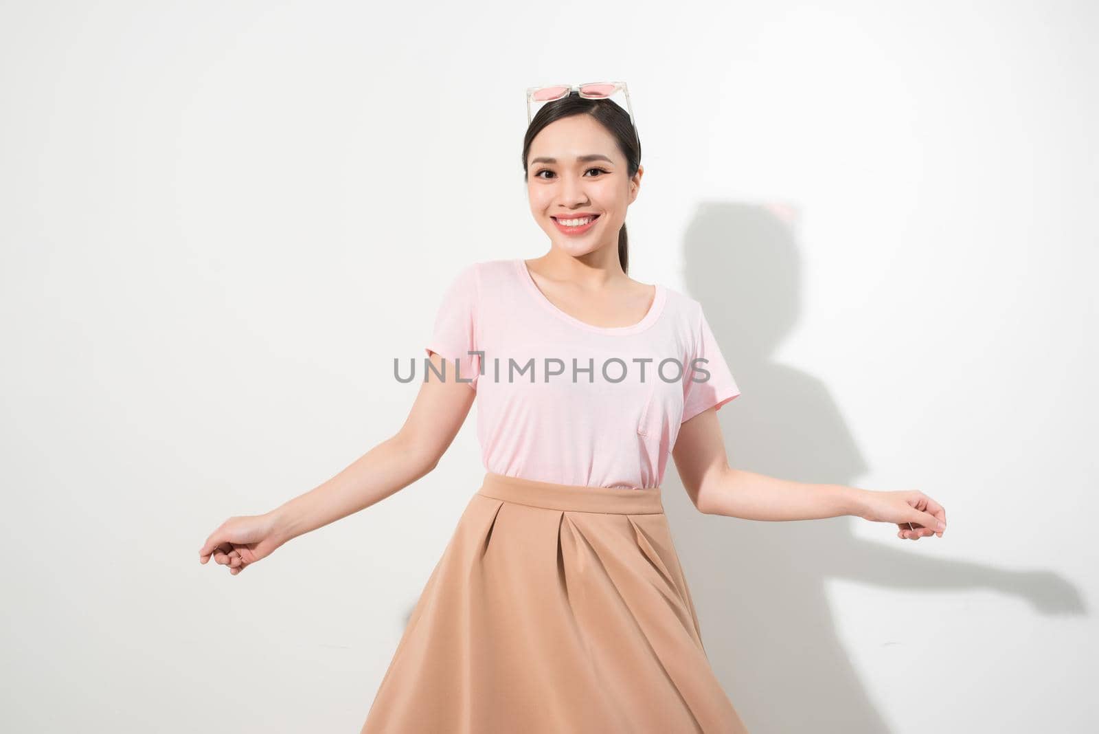 Magnificent girl dancing with smile in white studio. Indoor portrait of inspired caucasian lady in romantic outfit expressing happy emotions. by makidotvn