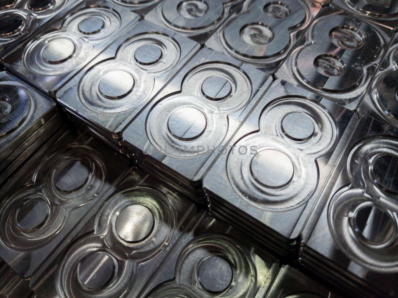 shiny metal machined digit 8 plates tiled tightly - close-up full frame background