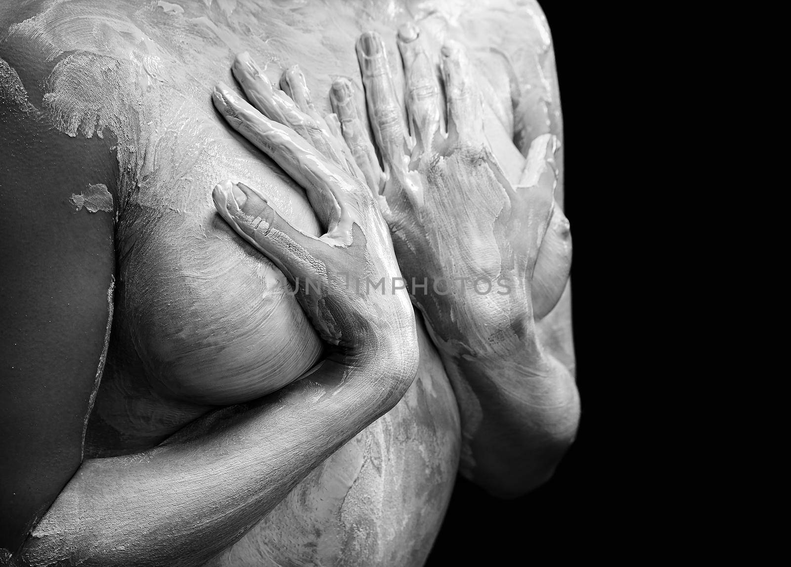 Mud treatment mask for body care. Woman covered in healing clay. Black and white image