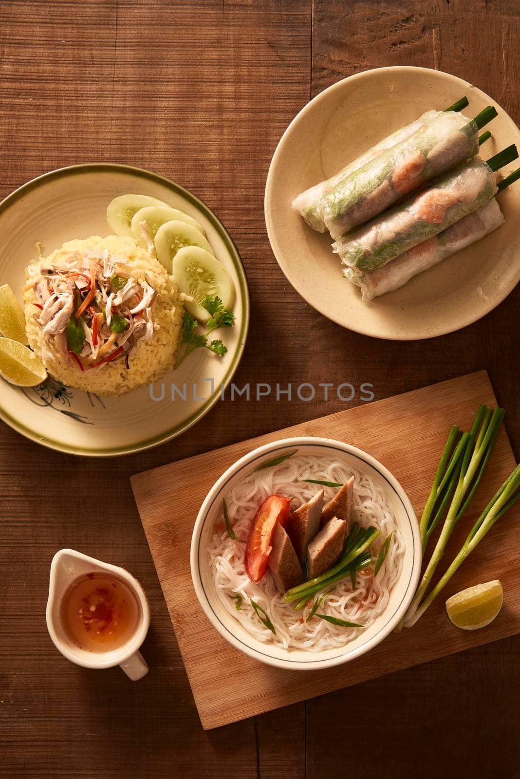 Assorted asian dinner, vietnamese food. Chicken rice, bun cha ca, noodles, spring rolls