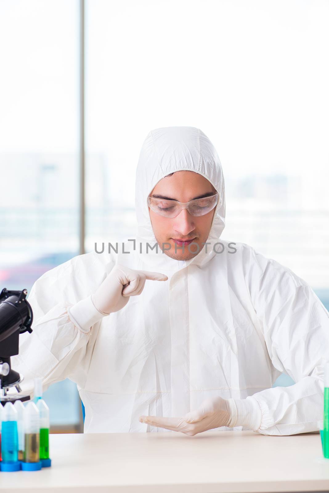 Young chemist student working in lab on chemicals