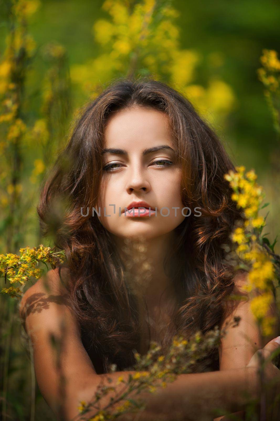 Portrait of a young woman on flowers field blured background
