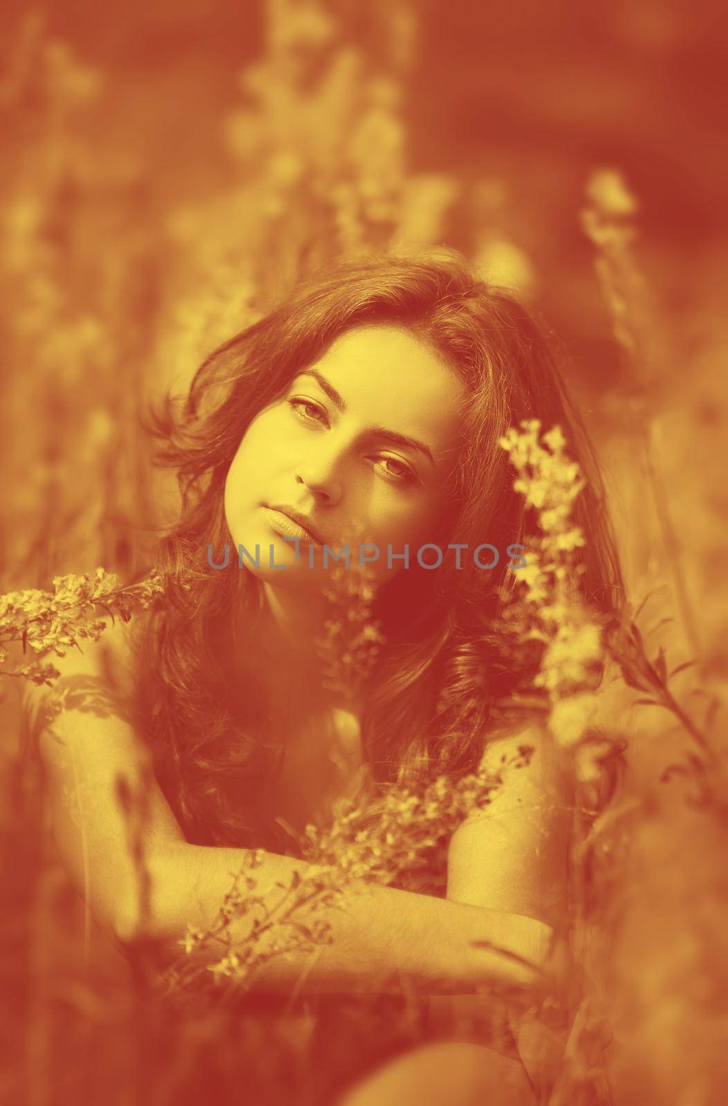 Duotone yellow and red image of young woman with wild flowers on background