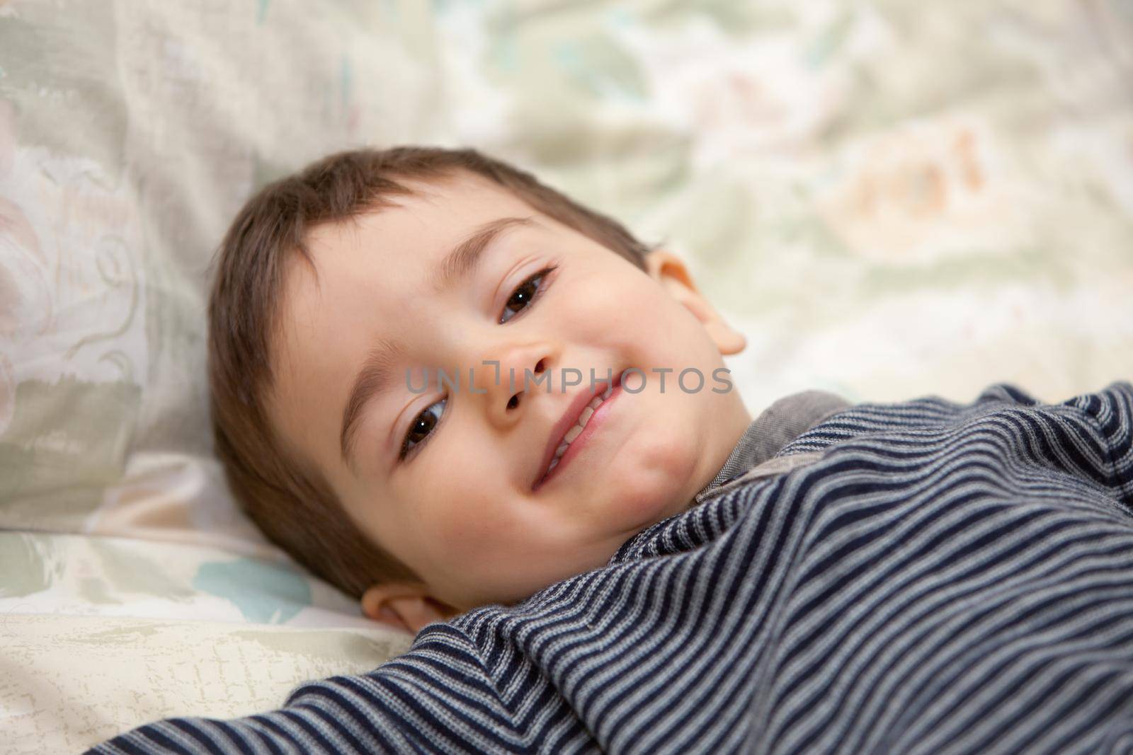 Boy lay on a bed and smiling