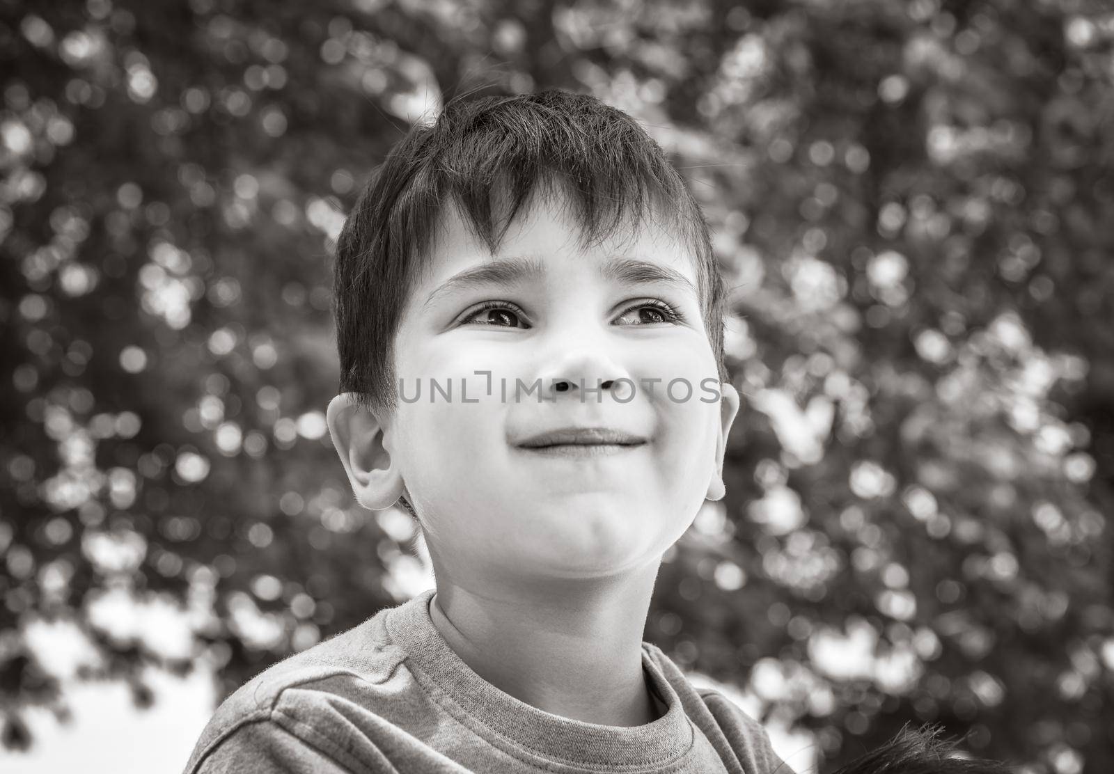 Family and happy lifestyle concept. Portrait of a little boy on the background of a blurred cityscape. 