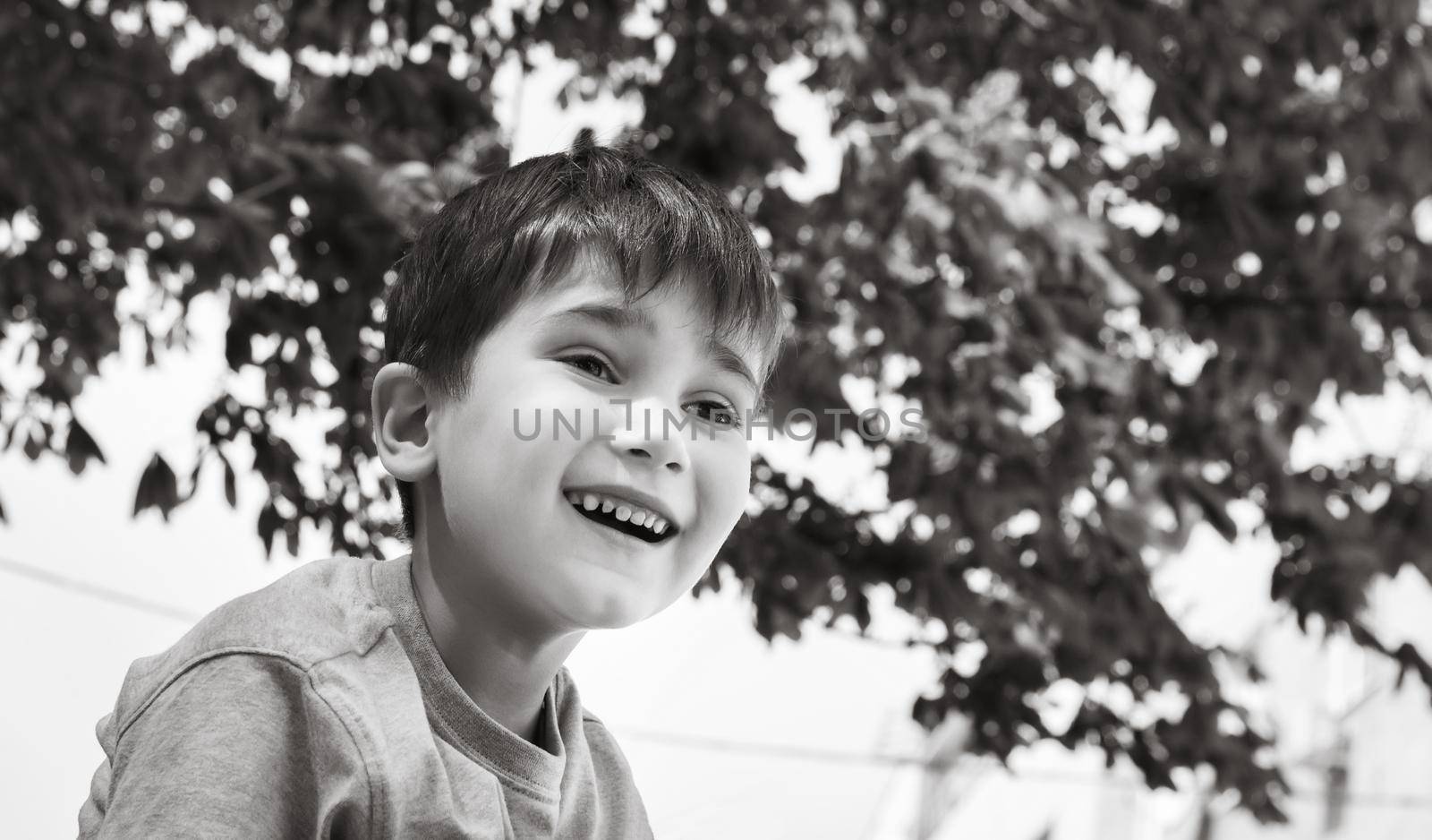 Family and happy lifestyle concept. Portrait of a little boy on the background of a blurred cityscape. 