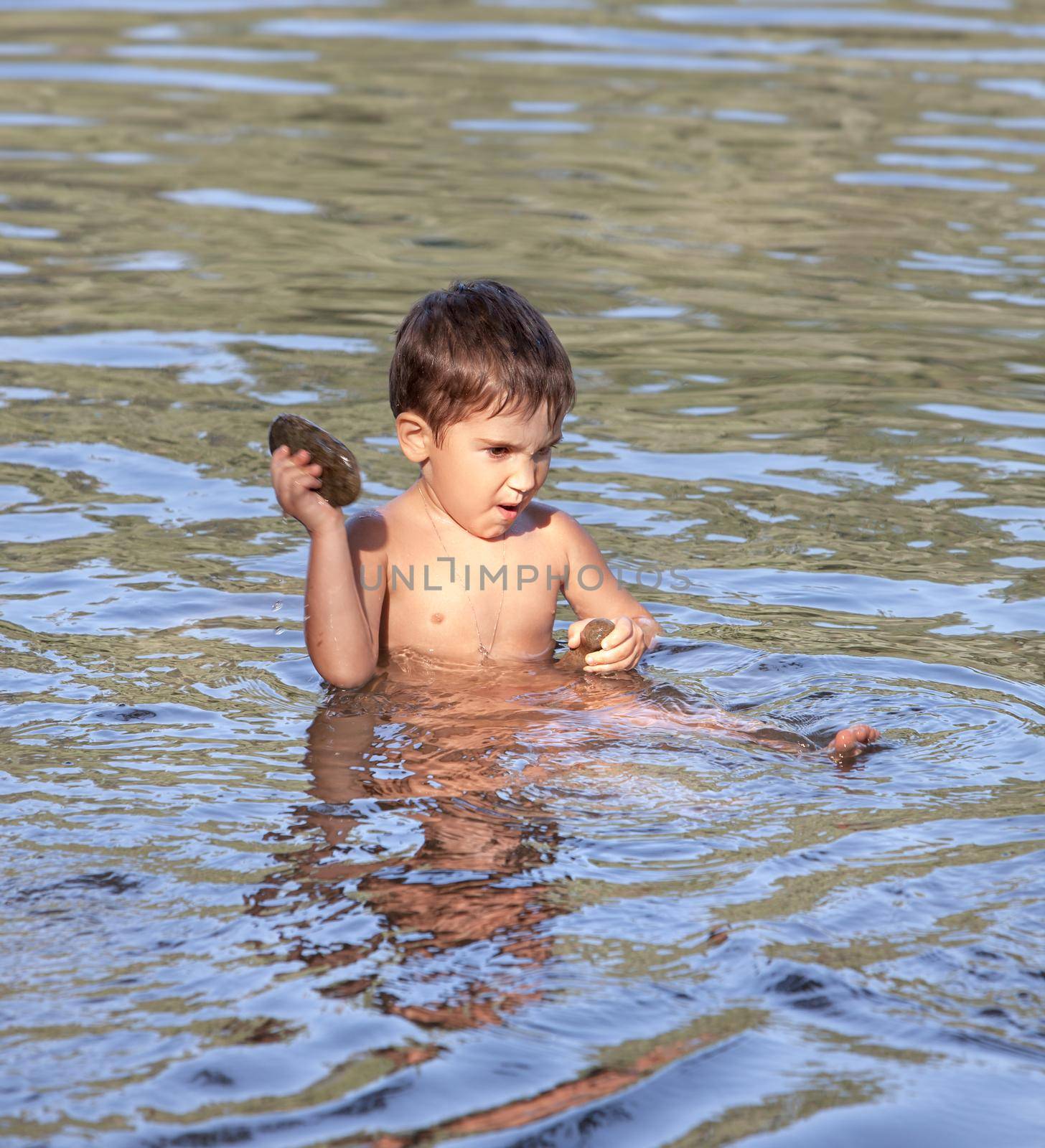 little funny boy playing in water