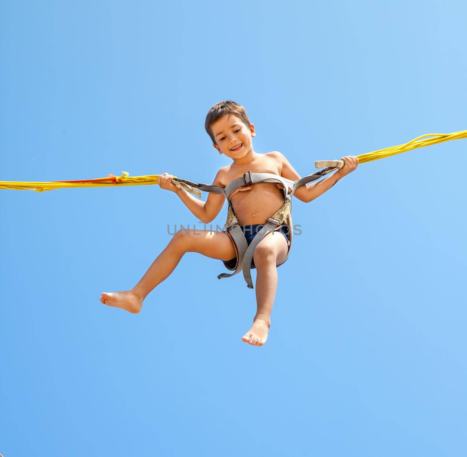 Boy jumping on trampoline by palinchak