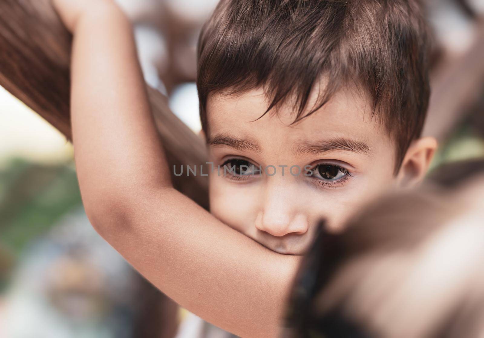 Cose-up portrait little boy outdoor. The boy is watching something interesting