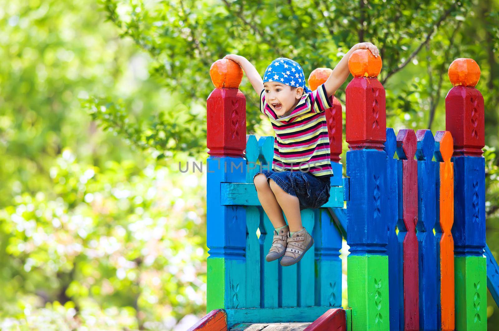 Full of energy happy young boy having fun on playground outside