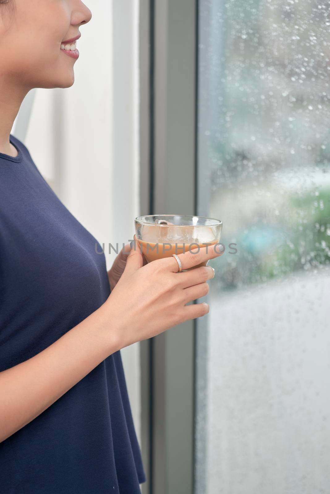 Attractive mixed female lifestyle enjoying a cup of tea looking out the window