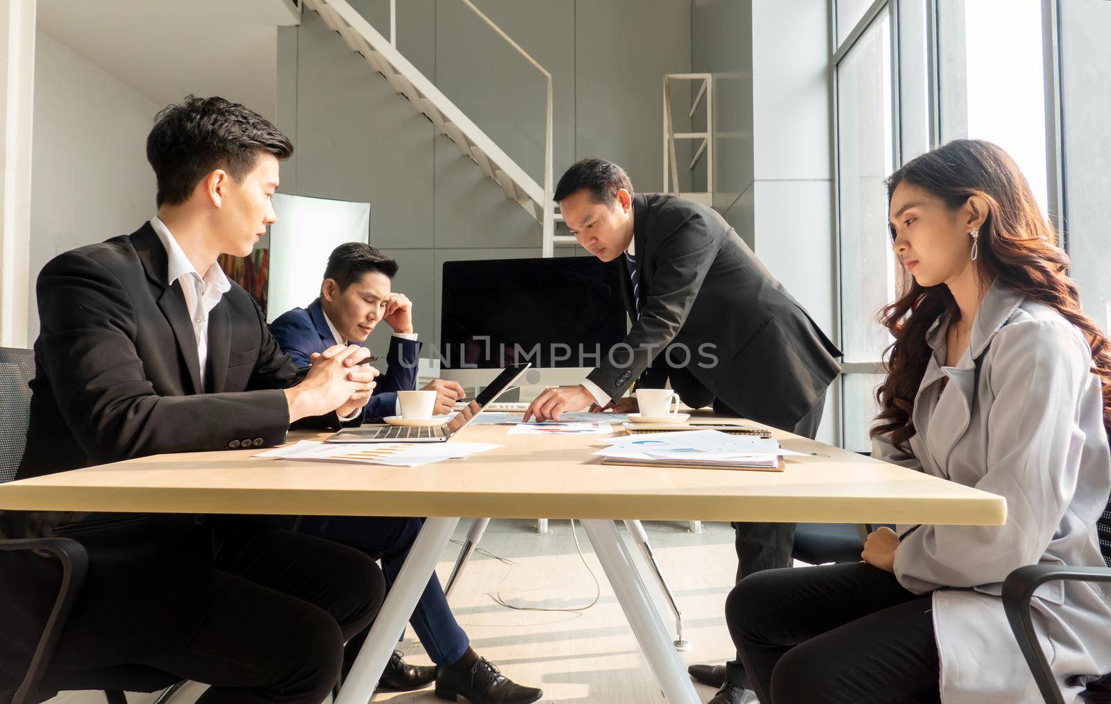 Shot of a group of businesspeople having a discussion in an office  by chuanchai